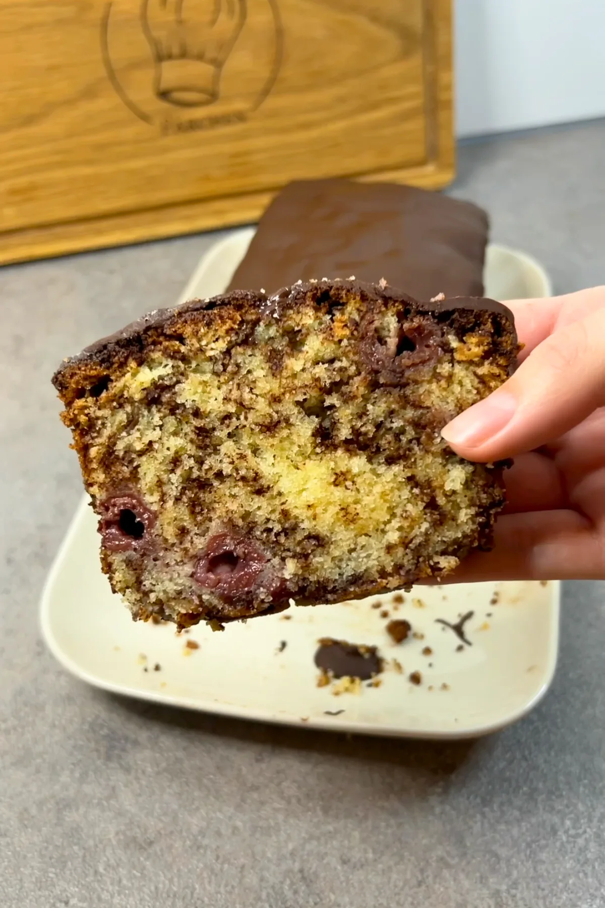 Ameisenkuchen Anschnitt in der Hand gehalten – saftige Krume mit Kirschen