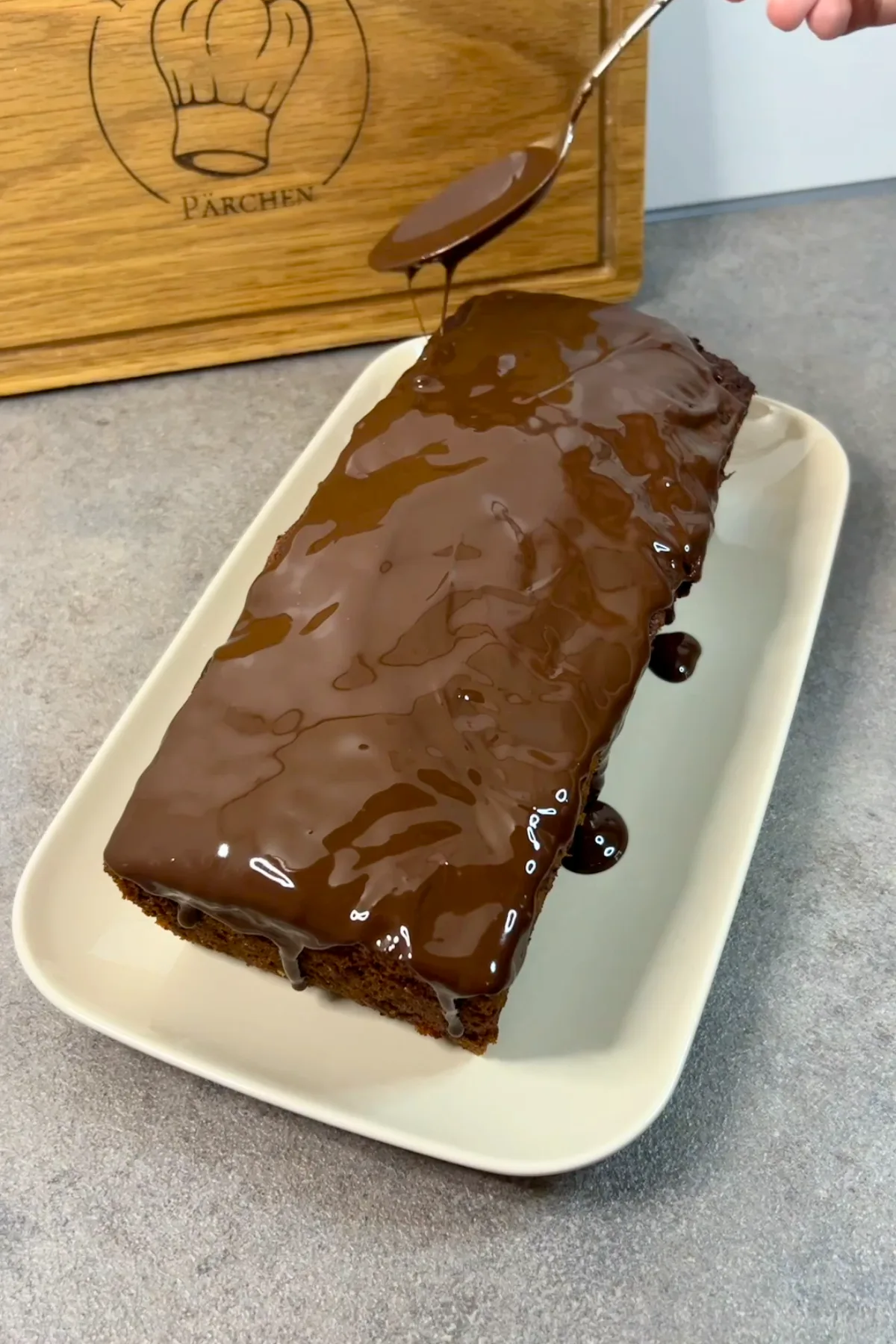 Fertig gebackener Ameisenkuchen wird mit Schokoglasur übergossen