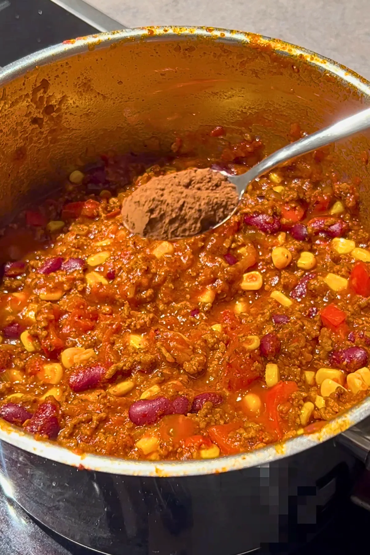 Kakaopulver wird ins fertige Chili con Carne eingerührt