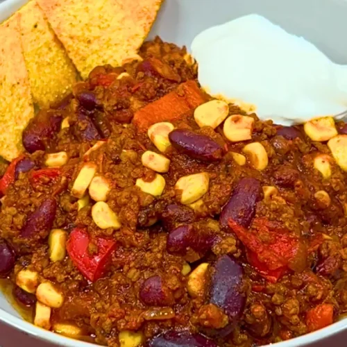 Chili con Carne in einer Schüssel mit Tortilla-Chips und Sauerrahm