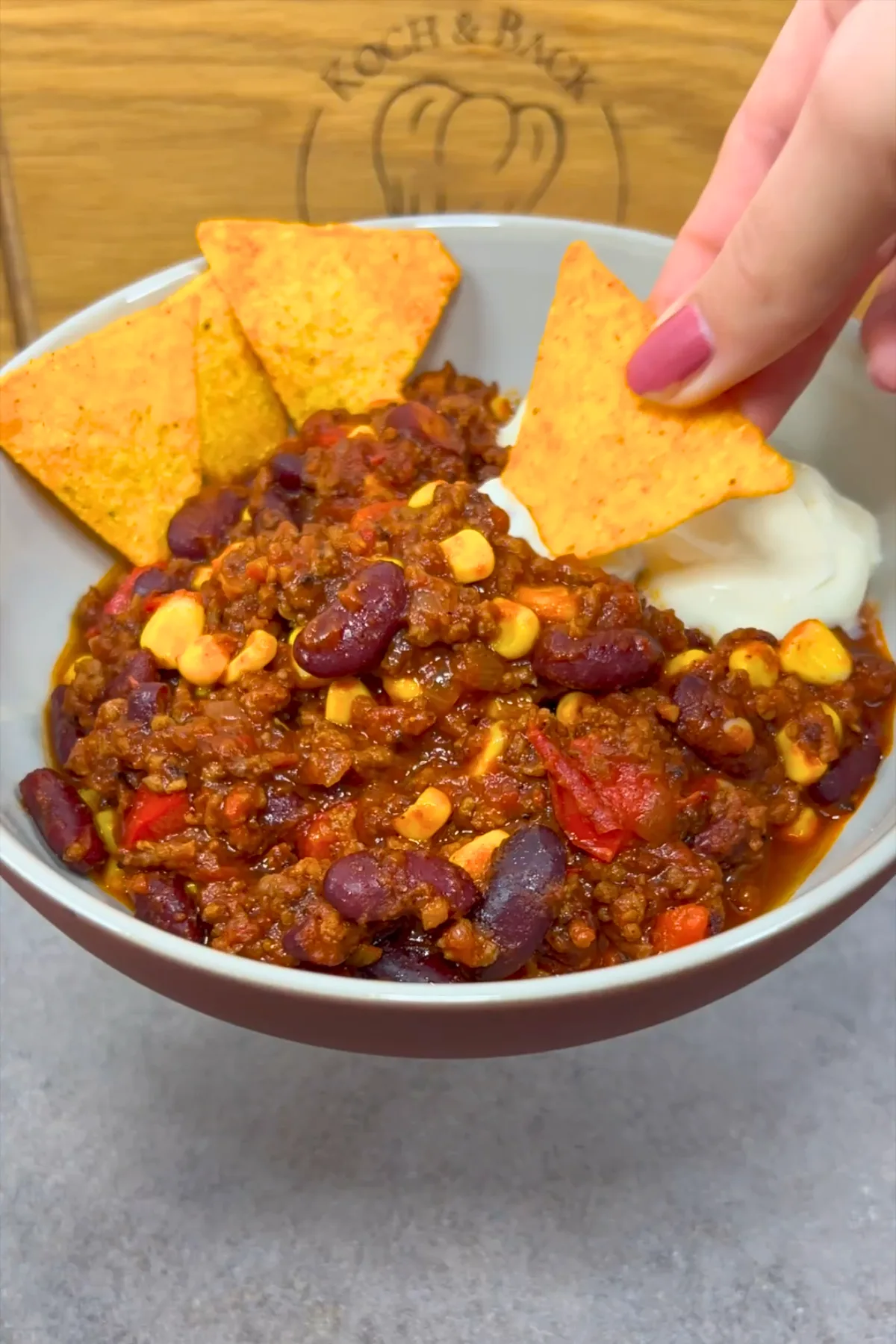 Fertige Schüssel Chili con Carne mit Tortilla-Chips und Sauerrahm