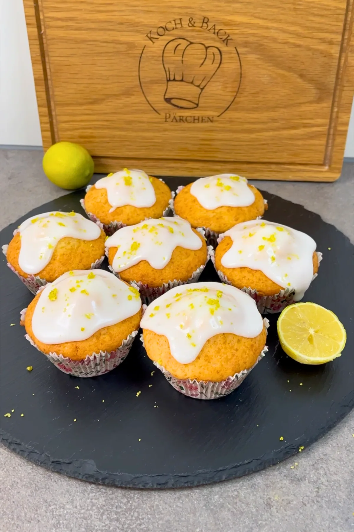 Fertige Zitronenmuffins mit Glasur auf einem Schiefertablett