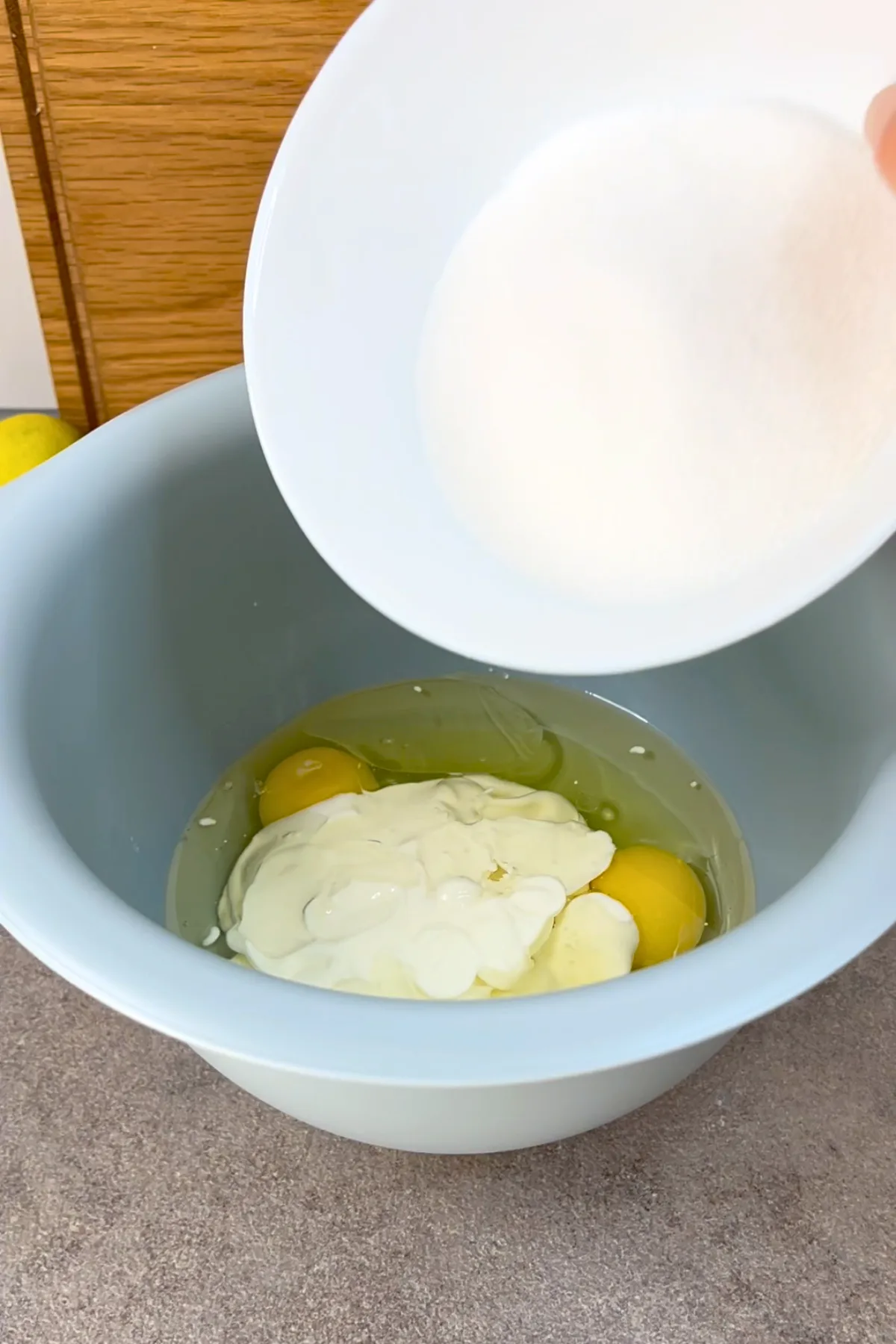Eier, Joghurt und Zucker werden in eine Schüssel gegeben