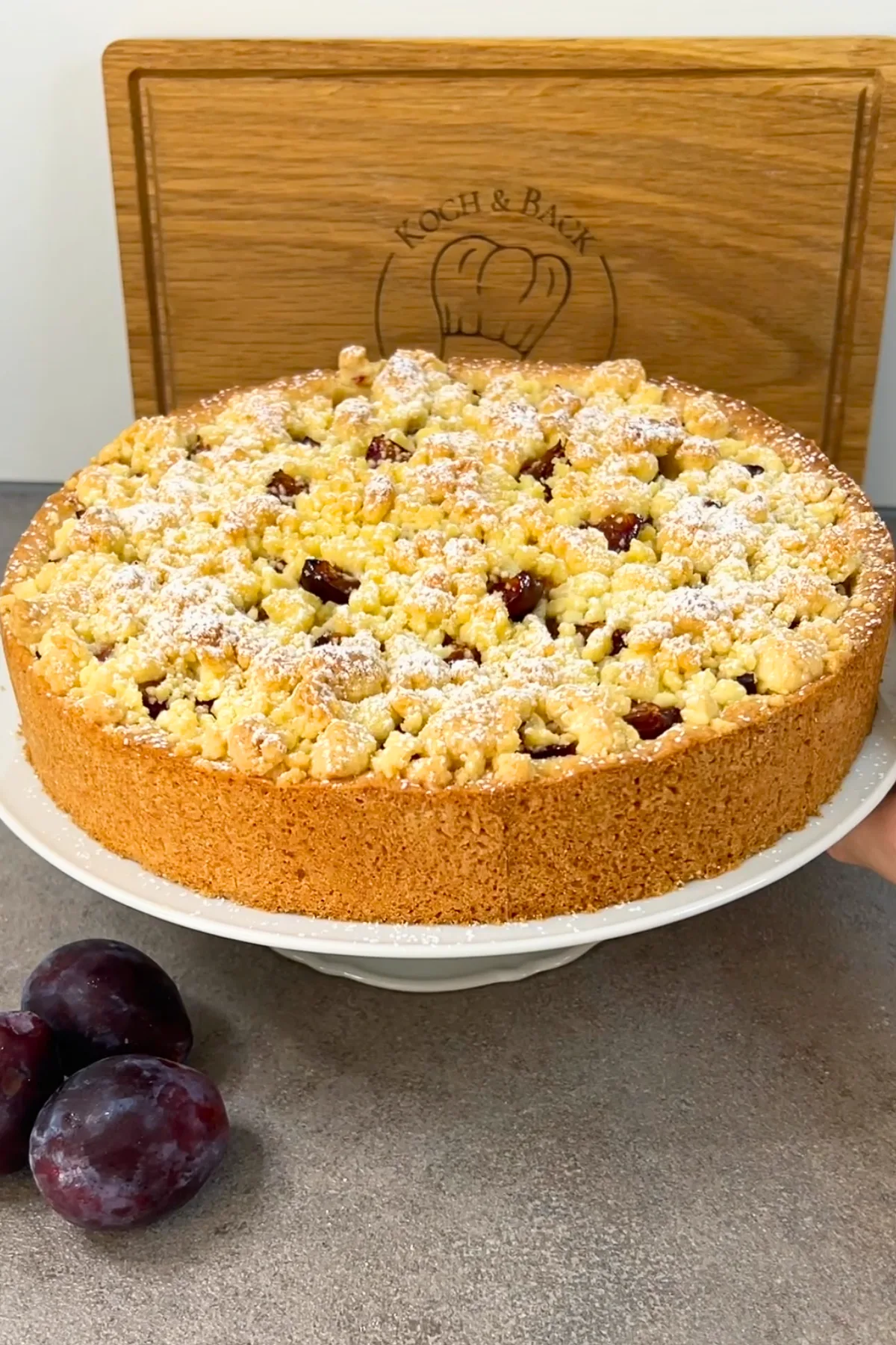 Fertiger Zwetschgenkuchen mit Streuseldecke auf einer Kuchenplatte