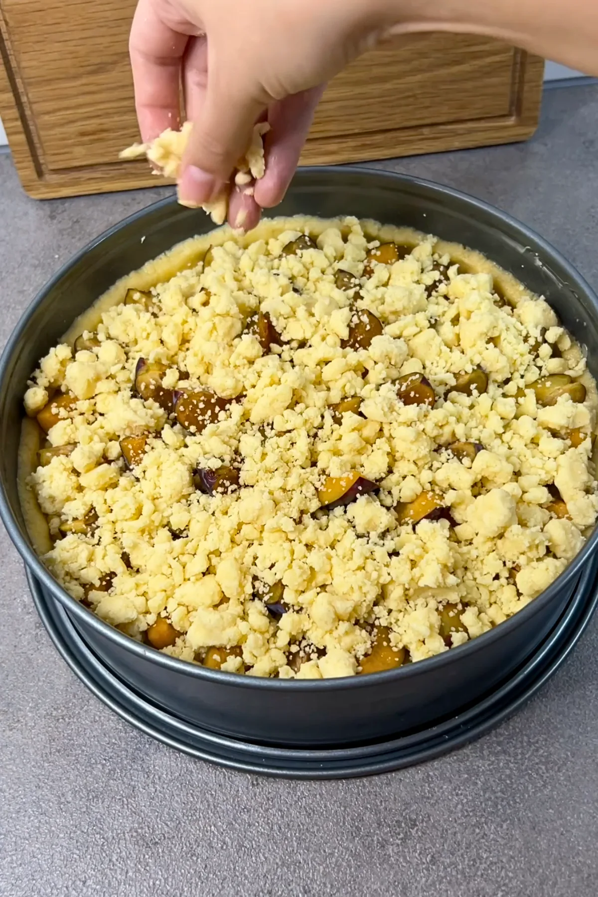 Streusel werden über die Zwetschgen aufgestreut