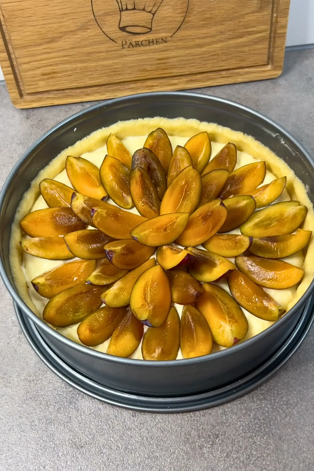 Zwetschgen werden fächerförmig auf dem Pudding eingelegt