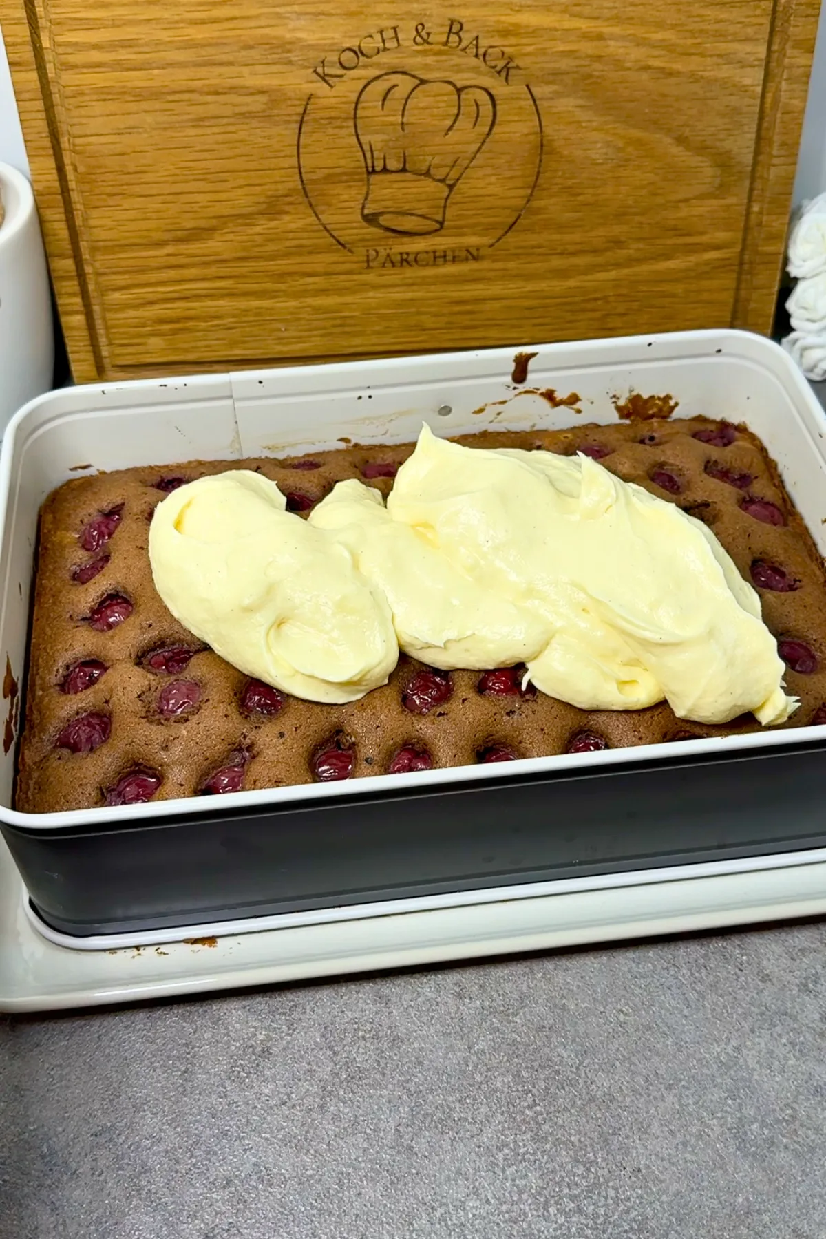 Vanillebuttercreme wird auf dem gebackenen Donauwelle-Boden aufgetragen