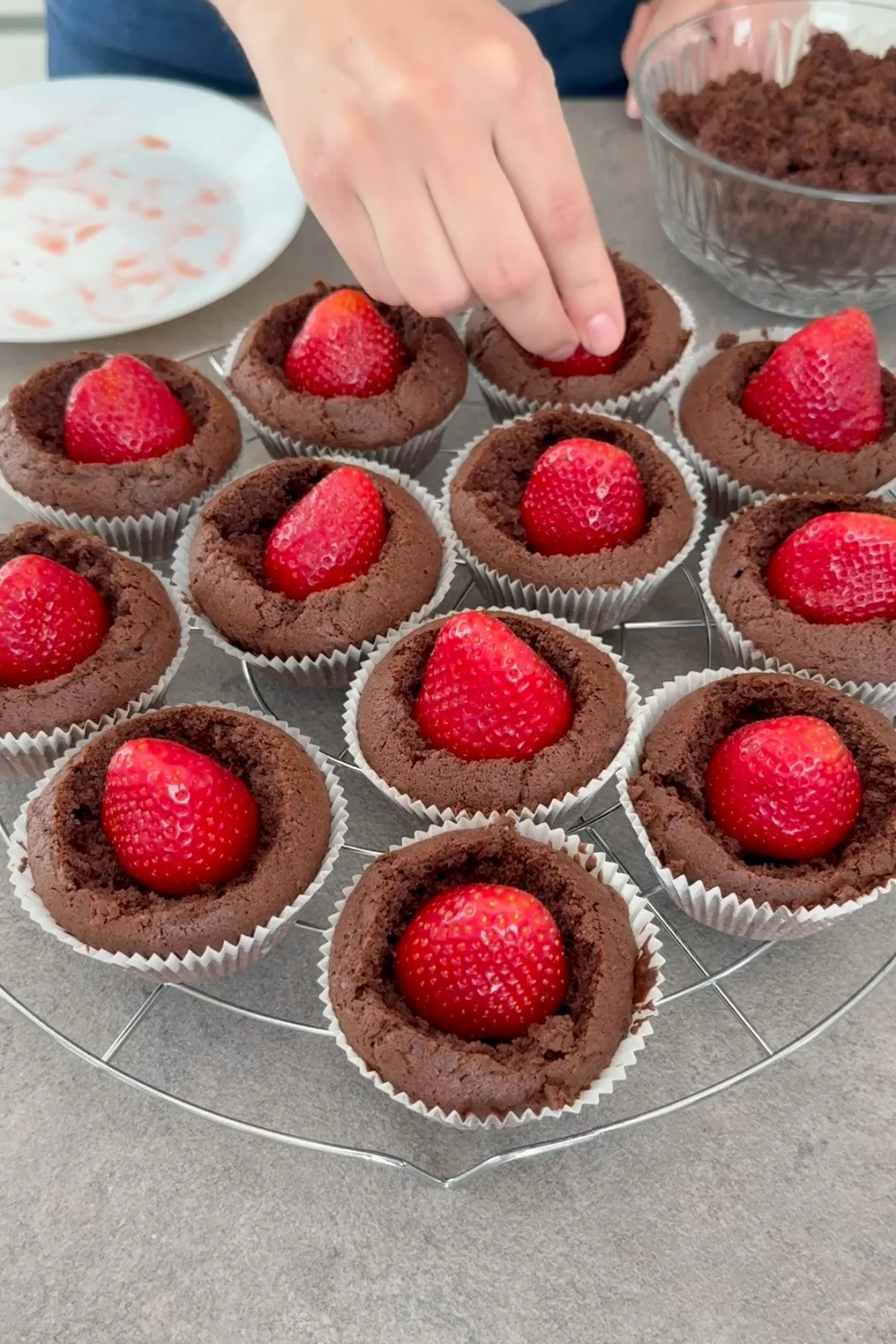Erdbeeren werden in die ausgehöhlten Maulwurfmuffins gesetzt