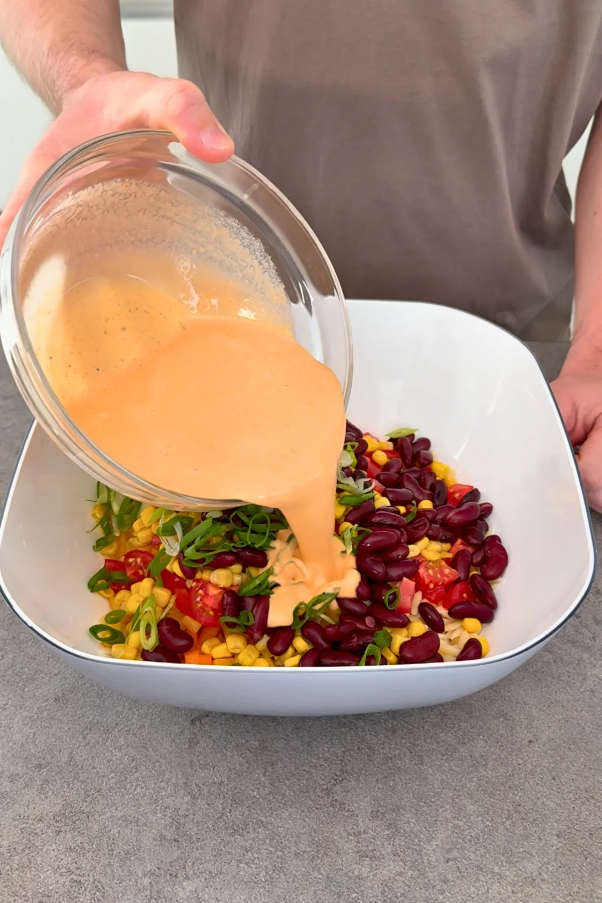 Cremiges Pesto Rosso Dressing wird über Orzo Nudelsalat gegossen