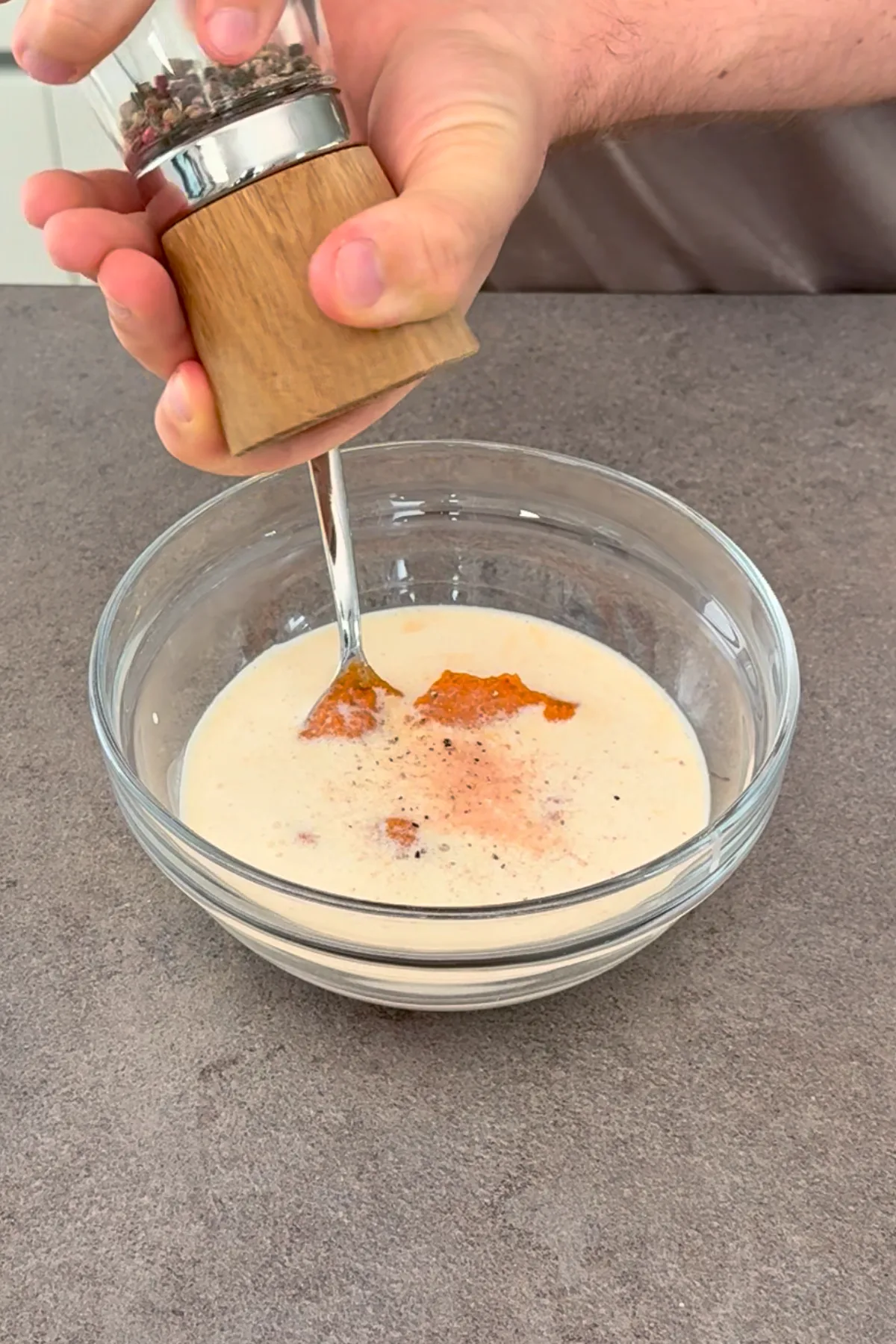 Pesto Rosso Sahne Dressing für Orzo Nudelsalat in Glasschüssel anrühren