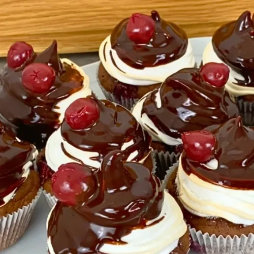 Schwarzwälder Kirsch Muffins auf weißem Teller mit Schokoladenguss und Kirsche