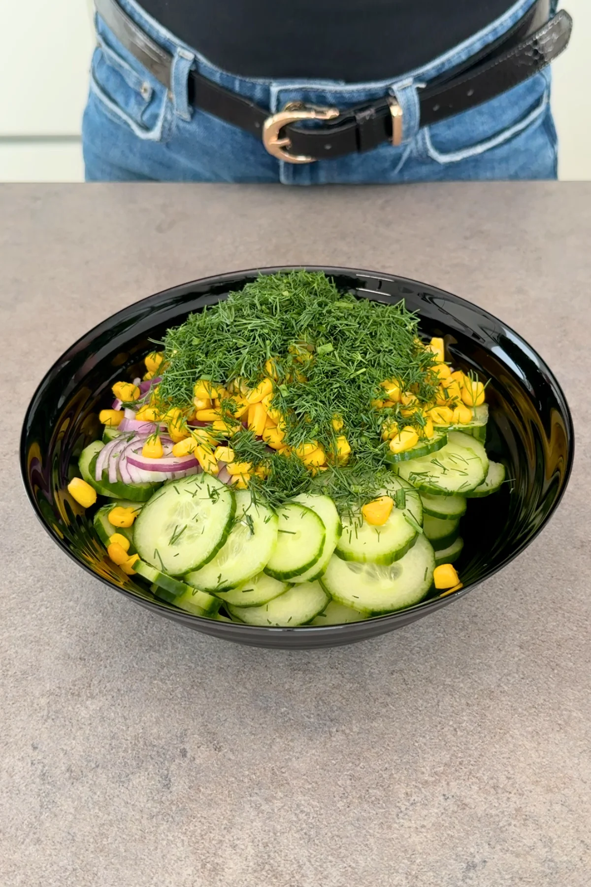 Joghurt-Dressing in Glasschüssel mit Senf, Chiliflocken und frischer Knoblauchzehe – vor dem Rühren