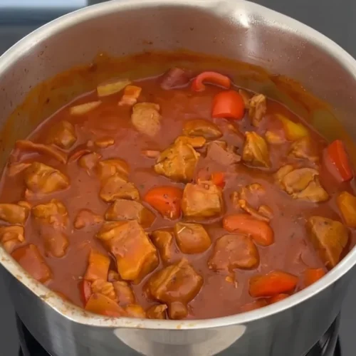 Fertiger Schaschliktopf mit Fleisch und Paprika in einem Edelstahltopf auf dem Herd