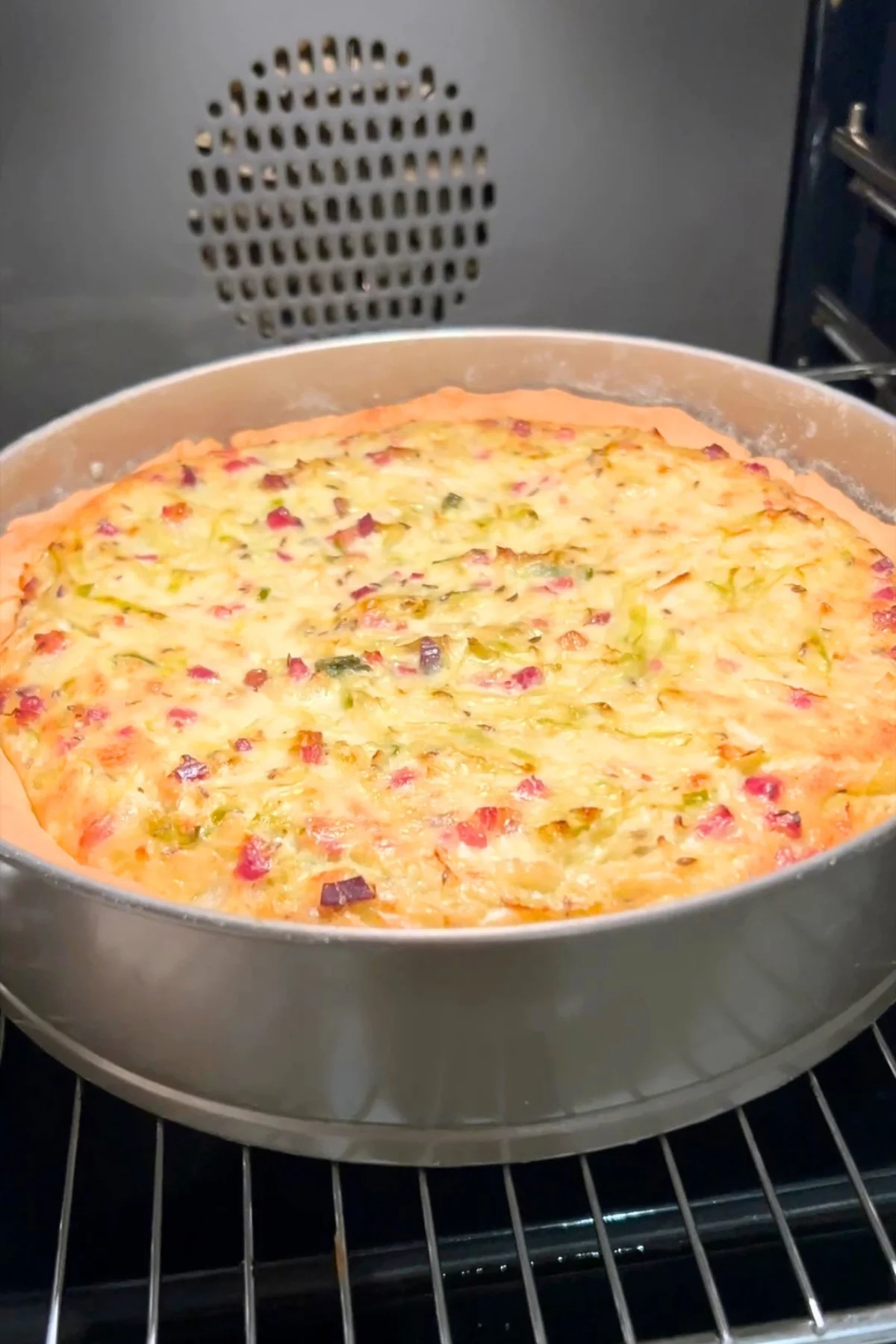 Fertig gebackener Krautkuchen in der runden Backform auf dem Rost im Backofen